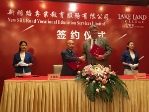 Luke Wang, head investor of New Silk Road Educational Services, and Jim Hull, Lake Land College vice president for workforce solutions and community education, shake hands after signing a ceremonial agreement to work together on an educational endeavor between Lake Land College and China. Hull visited Shanghai and Hong Kong on his August trip to China. 