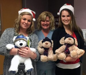 Kay Jewelers employees Megan Cozadd (left) and Darienne Lester (right) pose with Nancy Oberlink, RN, from Women and Children’s Care, and some of the approximately 60 stuffed animals Kay Jewelers donated to HSHS St. Anthony’s Memorial Hospital on Christmas Eve for pediatric patients. 